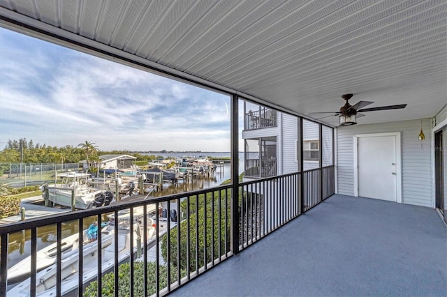 balcony featuring a water view and ceiling fan