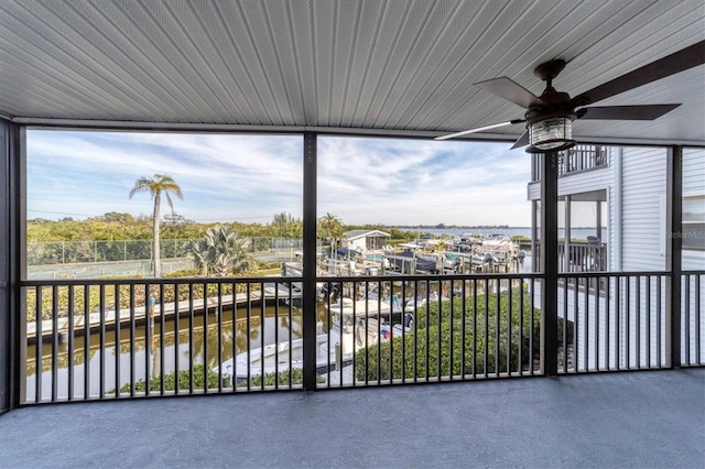 unfurnished sunroom with ceiling fan