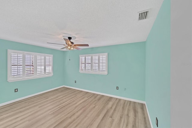 empty room with a textured ceiling, ceiling fan, and light wood-type flooring