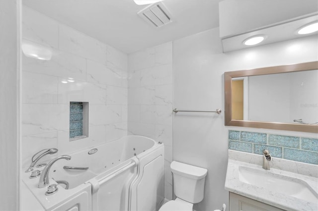 bathroom with toilet, tasteful backsplash, vanity, and tile walls