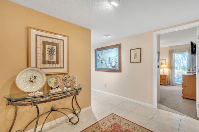 hall with light tile patterned floors and a textured ceiling