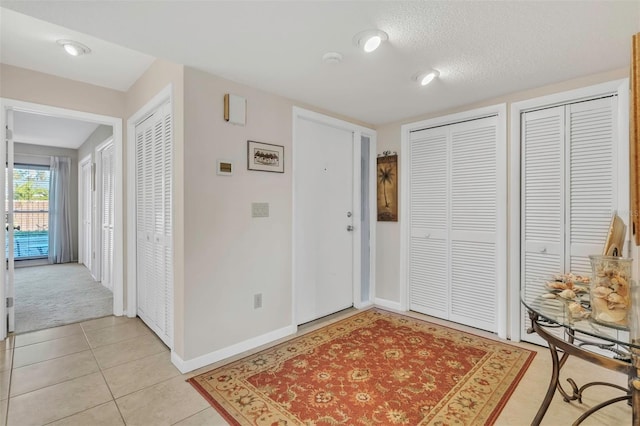 tiled foyer featuring a textured ceiling