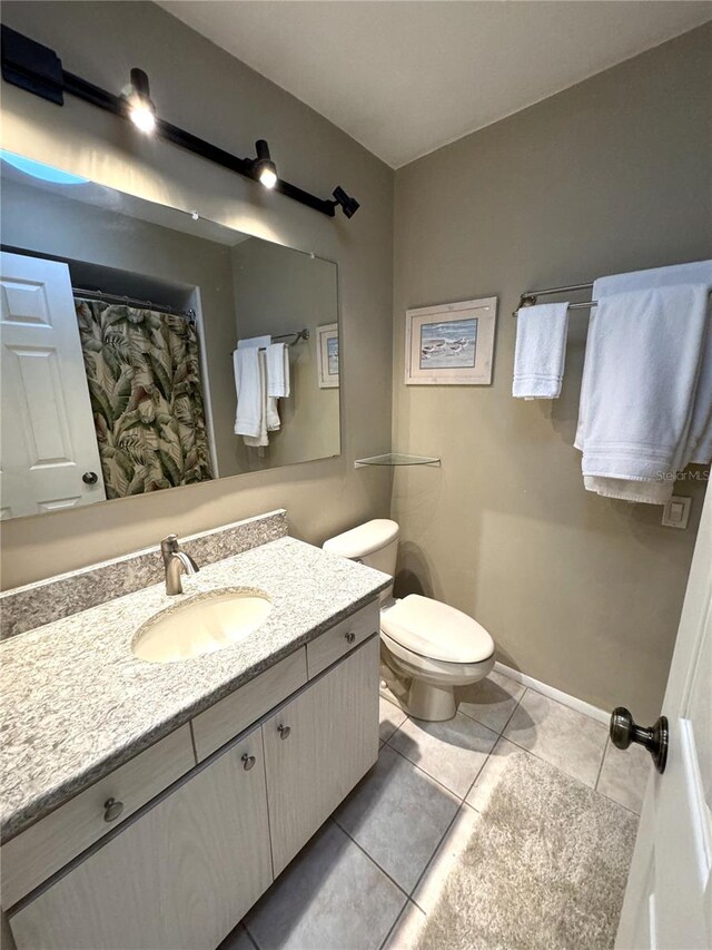 bathroom with tile patterned flooring, vanity, and toilet