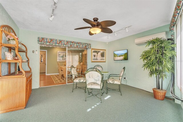 dining room featuring carpet flooring, a wall mounted AC, ceiling fan, and track lighting