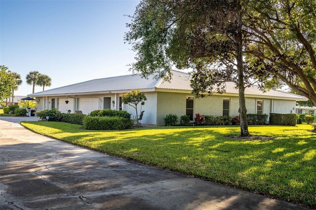 ranch-style home featuring a front yard and a garage