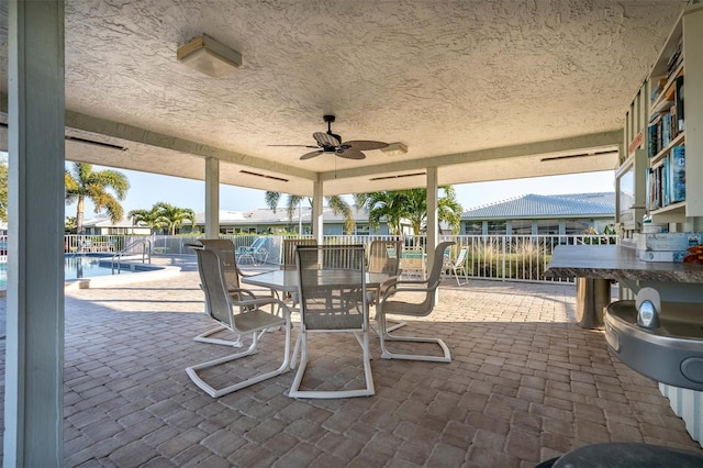 view of patio with ceiling fan and a community pool