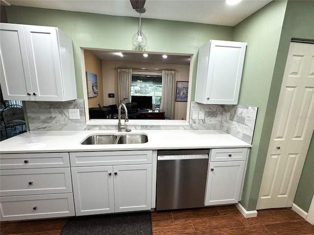 kitchen featuring backsplash, white cabinets, sink, hanging light fixtures, and stainless steel dishwasher