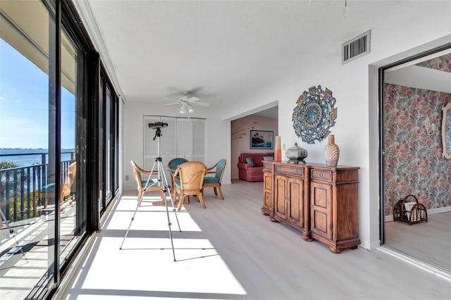 interior space with ceiling fan and a water view