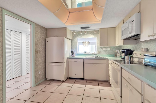 kitchen with white appliances, sink, light tile floors, a textured ceiling, and rail lighting