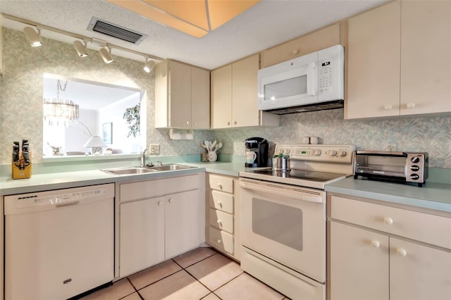 kitchen featuring white appliances, sink, light tile floors, a textured ceiling, and tasteful backsplash