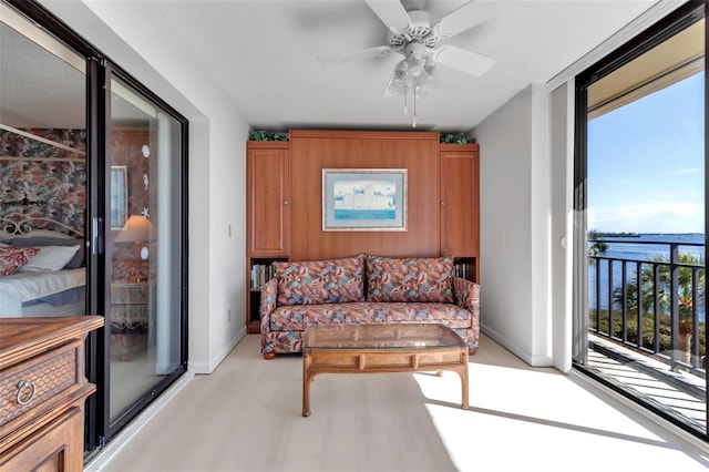 living room featuring a water view, ceiling fan, and light hardwood / wood-style flooring