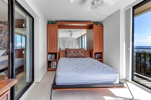 bedroom featuring a water view, ceiling fan, and light hardwood / wood-style flooring