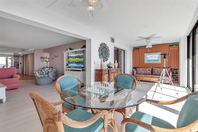 dining area with ceiling fan and light hardwood / wood-style flooring