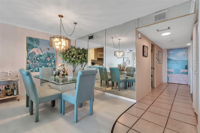 tiled dining room with a textured ceiling and a chandelier