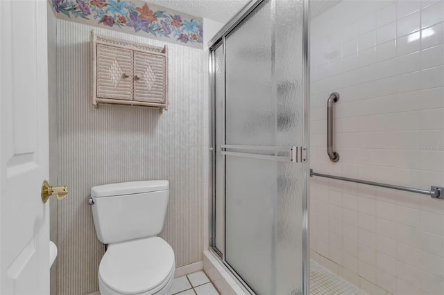 bathroom featuring an enclosed shower, a textured ceiling, tile floors, and toilet