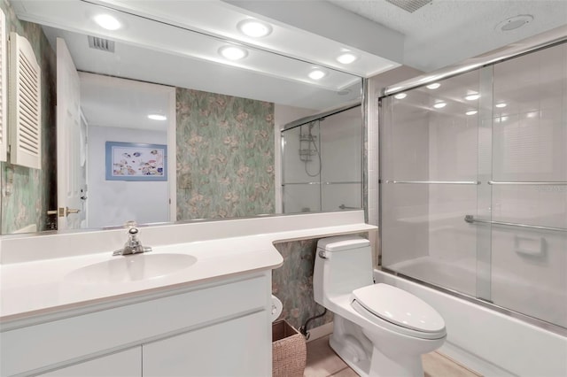 full bathroom with vanity, combined bath / shower with glass door, a textured ceiling, and toilet