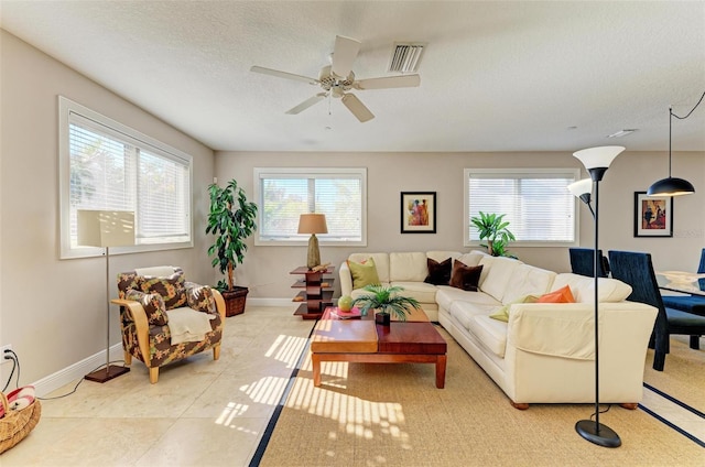 tiled living room featuring a textured ceiling and ceiling fan