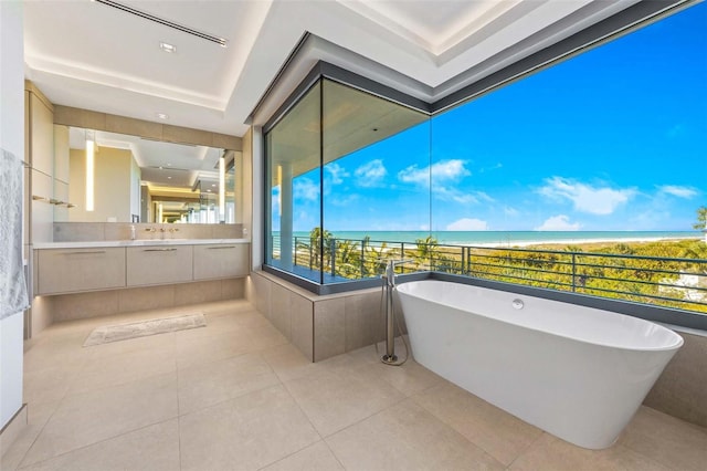 bathroom featuring a washtub, vanity, a water view, and tile patterned flooring