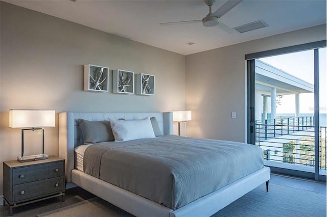 bedroom featuring ceiling fan, access to exterior, a water view, and dark colored carpet