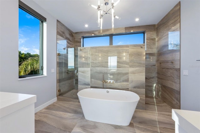 bathroom with independent shower and bath and an inviting chandelier