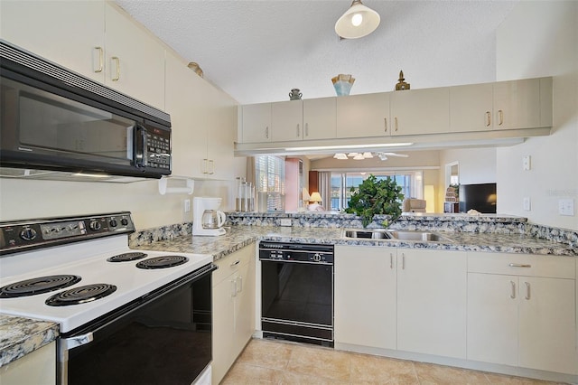 kitchen featuring black appliances, a textured ceiling, light tile floors, and light stone countertops