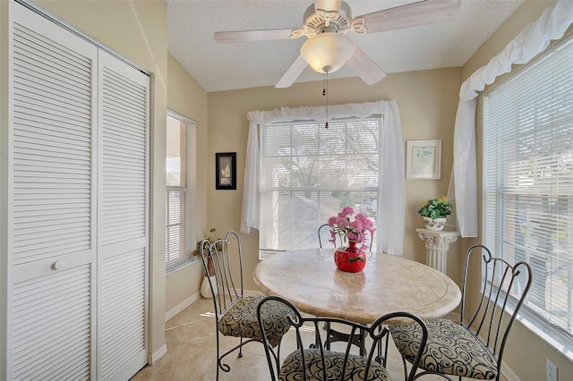 dining space featuring ceiling fan and a textured ceiling