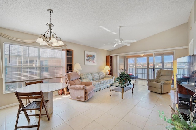 living room with vaulted ceiling, light tile floors, and ceiling fan with notable chandelier