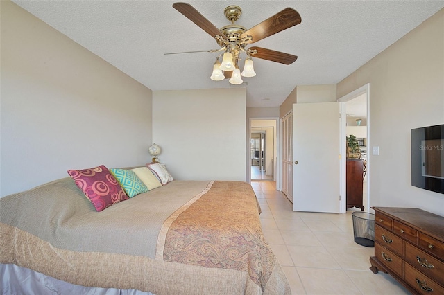 bedroom with a textured ceiling, ceiling fan, and light tile floors