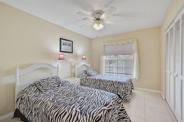 tiled bedroom with a textured ceiling, a closet, and ceiling fan