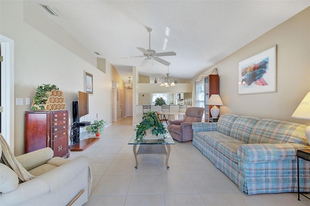 living room featuring tile flooring, a textured ceiling, and ceiling fan with notable chandelier