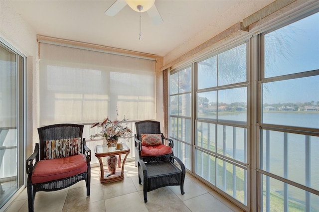 sunroom / solarium with a water view and ceiling fan