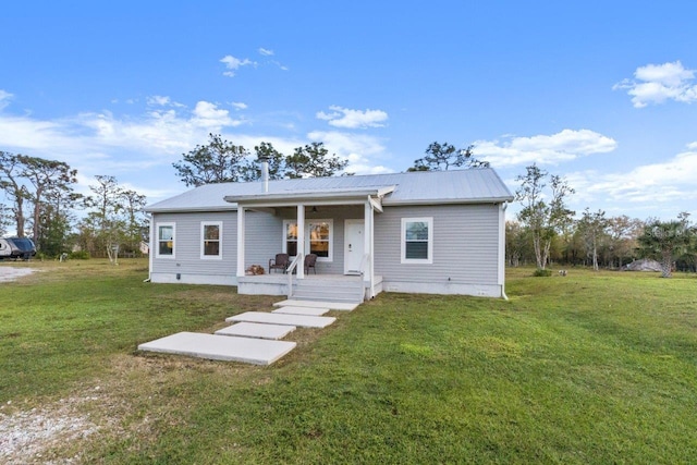 view of front of house featuring a front lawn, a porch, crawl space, and metal roof