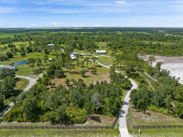 birds eye view of property featuring a forest view and a water view