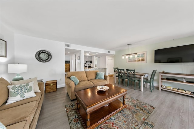 living room featuring light hardwood / wood-style flooring and an inviting chandelier