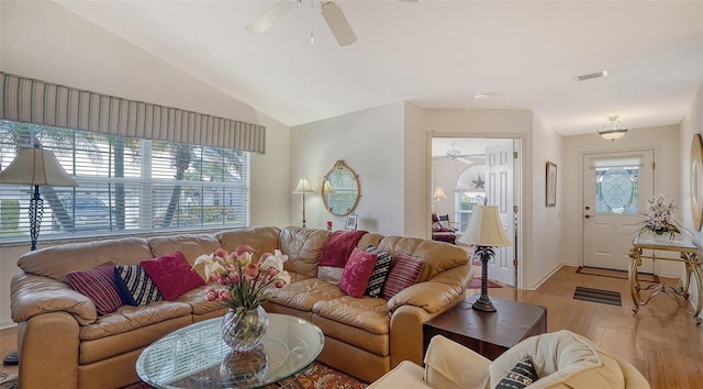 living room with vaulted ceiling, a healthy amount of sunlight, ceiling fan, and light wood-type flooring