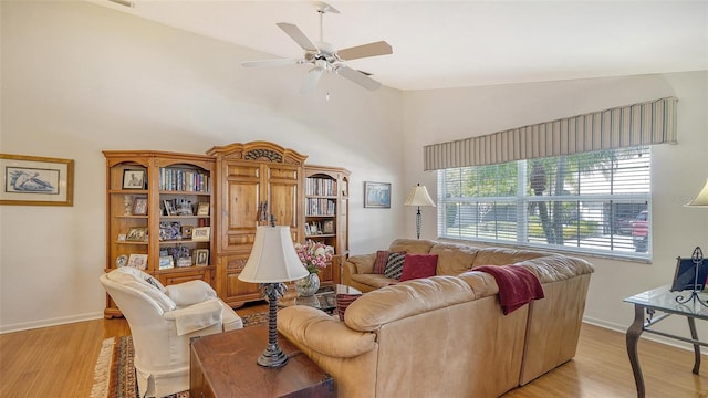 living room featuring ceiling fan, vaulted ceiling, and light wood-type flooring