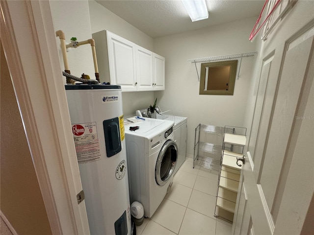 clothes washing area featuring light tile patterned floors, cabinet space, washer and dryer, a textured ceiling, and water heater