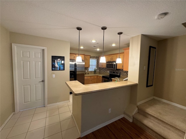 kitchen featuring stainless steel appliances, a peninsula, baseboards, decorative backsplash, and light countertops