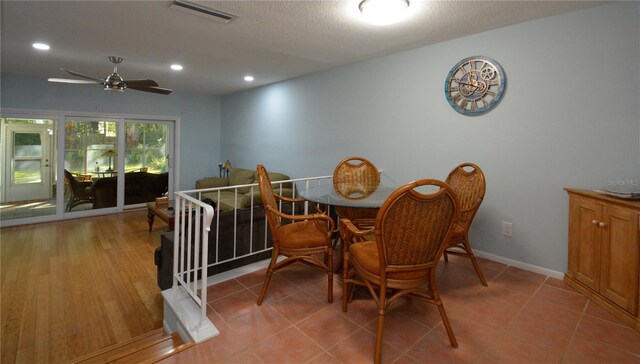 dining room featuring a textured ceiling, ceiling fan, and light wood-type flooring