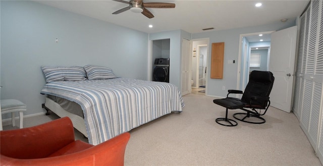 bedroom with ceiling fan, washer / dryer, and light colored carpet