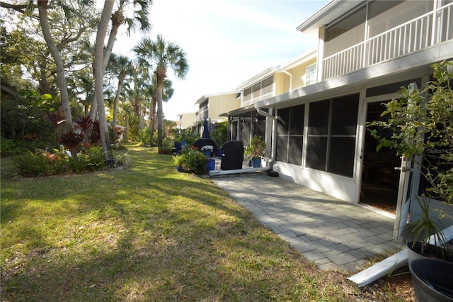 view of yard featuring a sunroom and a patio area