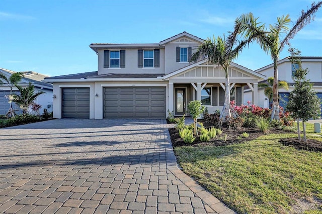 view of front of house featuring stucco siding, decorative driveway, and a garage