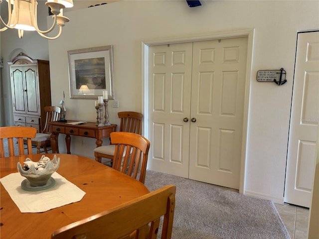 dining area featuring light tile flooring and an inviting chandelier