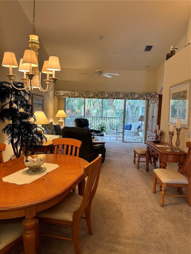 carpeted dining area with lofted ceiling and ceiling fan with notable chandelier