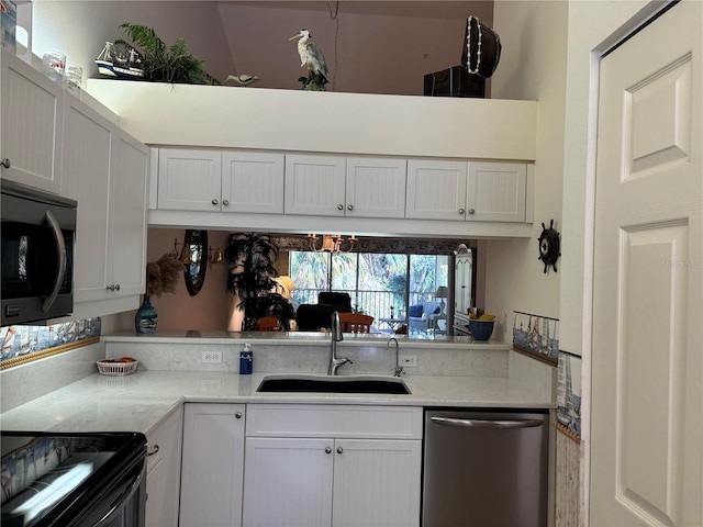 kitchen featuring light stone counters, white cabinetry, appliances with stainless steel finishes, and sink