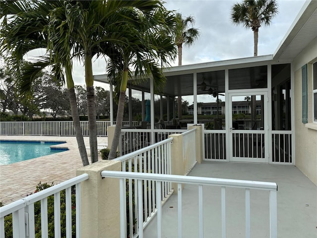 exterior space with ceiling fan and a fenced in pool