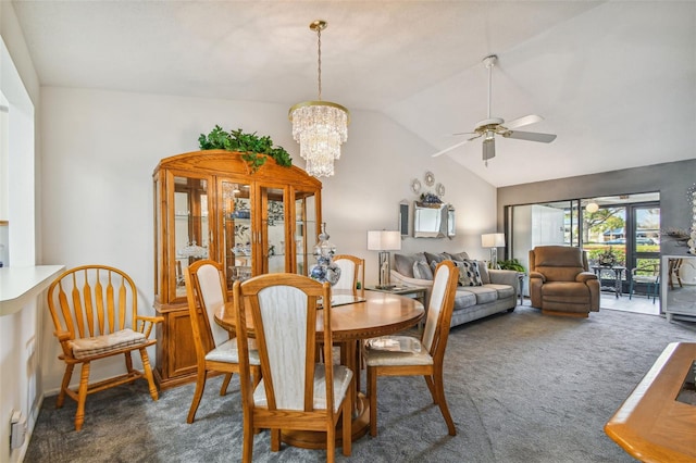 dining room with dark carpet, ceiling fan with notable chandelier, and lofted ceiling