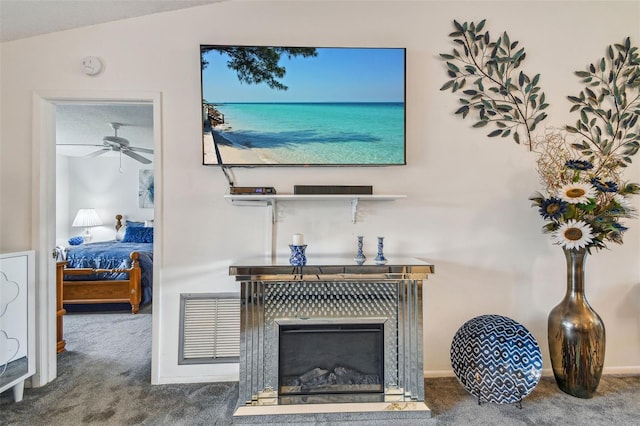 details featuring a tile fireplace, carpet, and ceiling fan