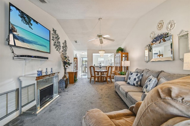 carpeted living room with ceiling fan with notable chandelier, a fireplace, a textured ceiling, and lofted ceiling