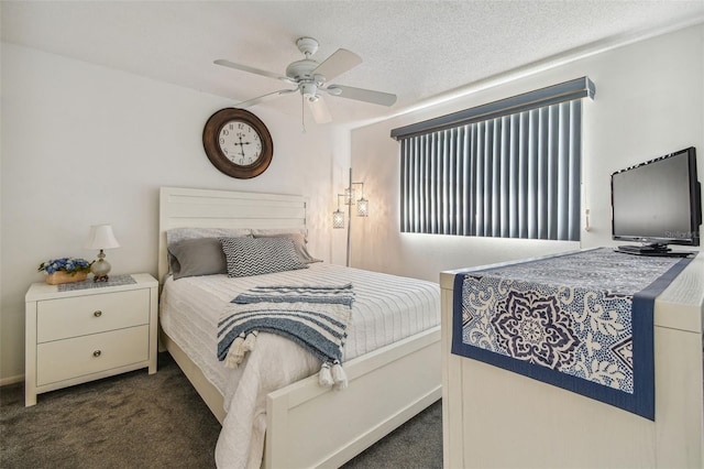 bedroom with ceiling fan, dark carpet, and a textured ceiling